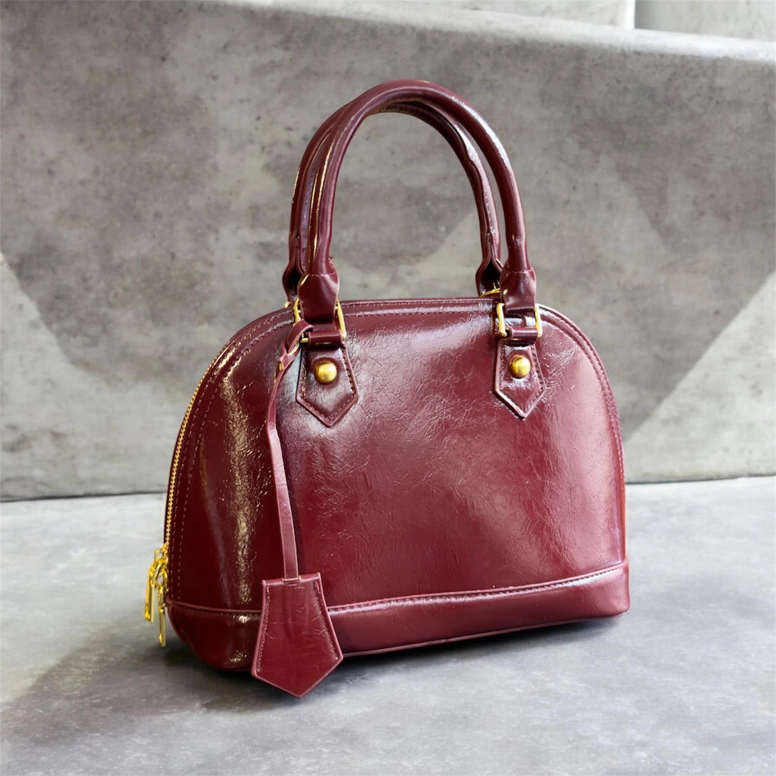 Cartera elegante de mano en material ecocuero con detalle colgante