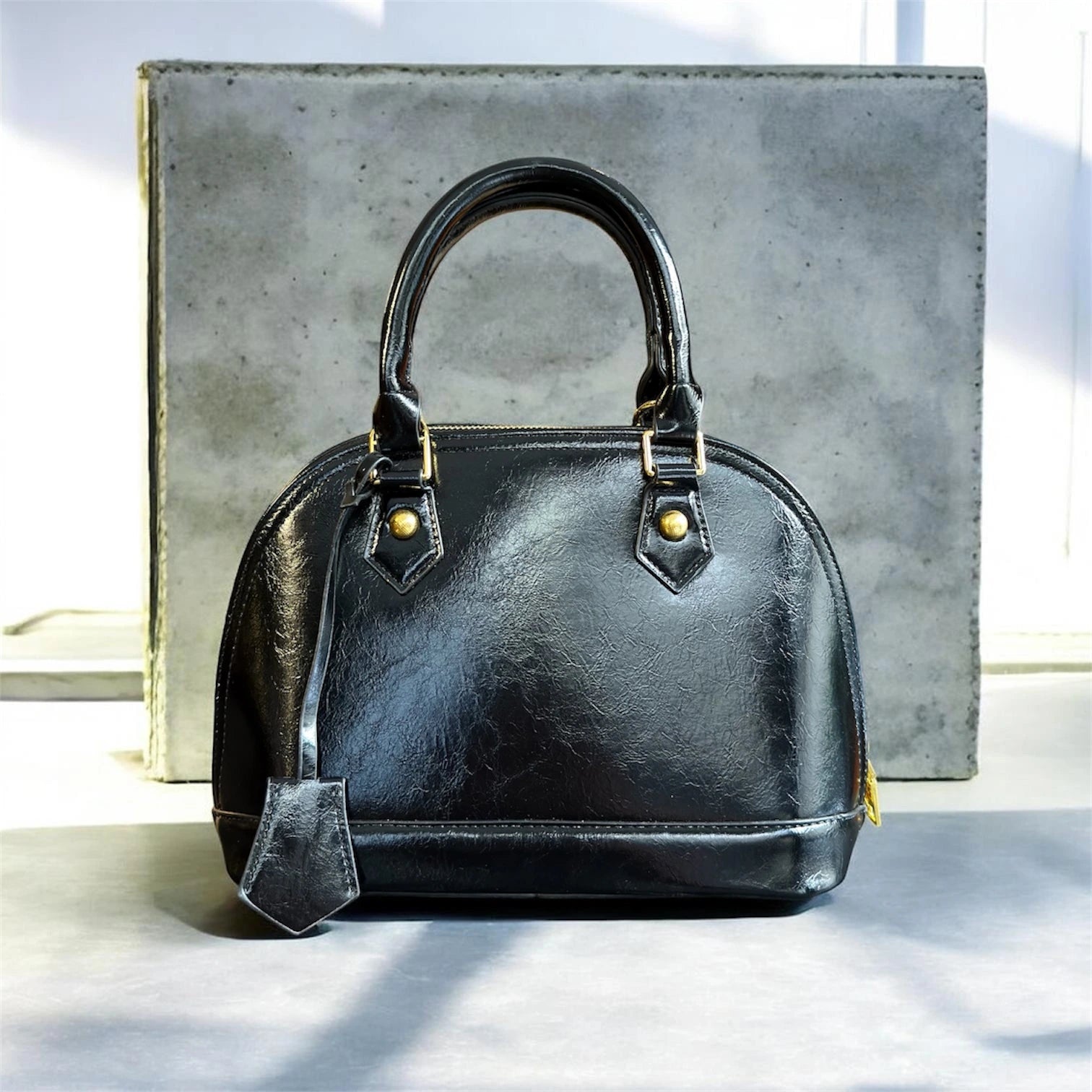 Cartera elegante de mano en material ecocuero con detalle colgante