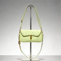 Bolso bandolera de gamuza en tono verde pálido con broche dorado ovalado distintivo y correa de cadena, estilo sofisticado y minimalista.