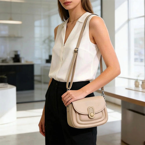 Cartera tipo crossbody con silueta moderna, tapa frontal y cierre distintivo, ideal para un estilo urbano y sofisticado.