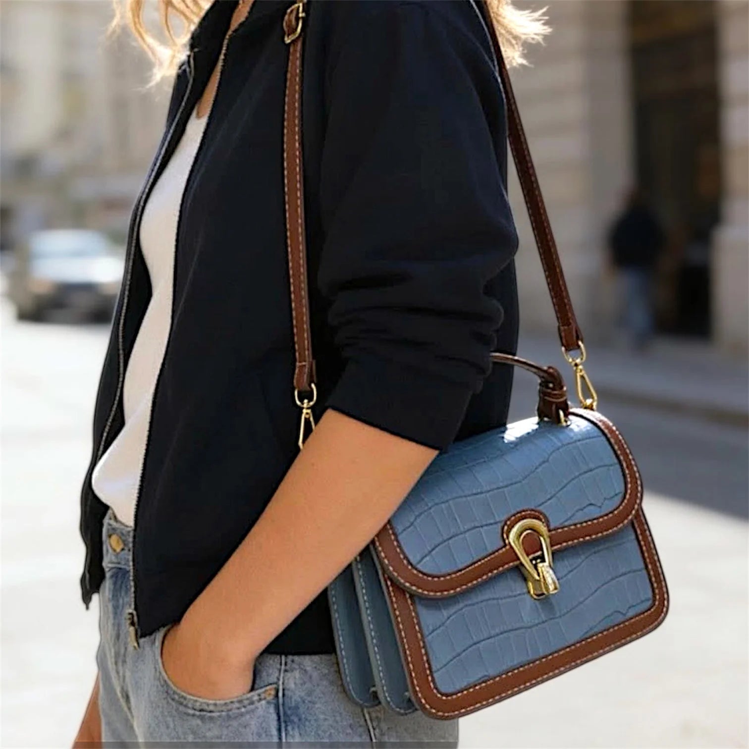 Bolso de hombro con textura de cocodrilo, costuras decorativas en contraste y cierre metálico dorado.