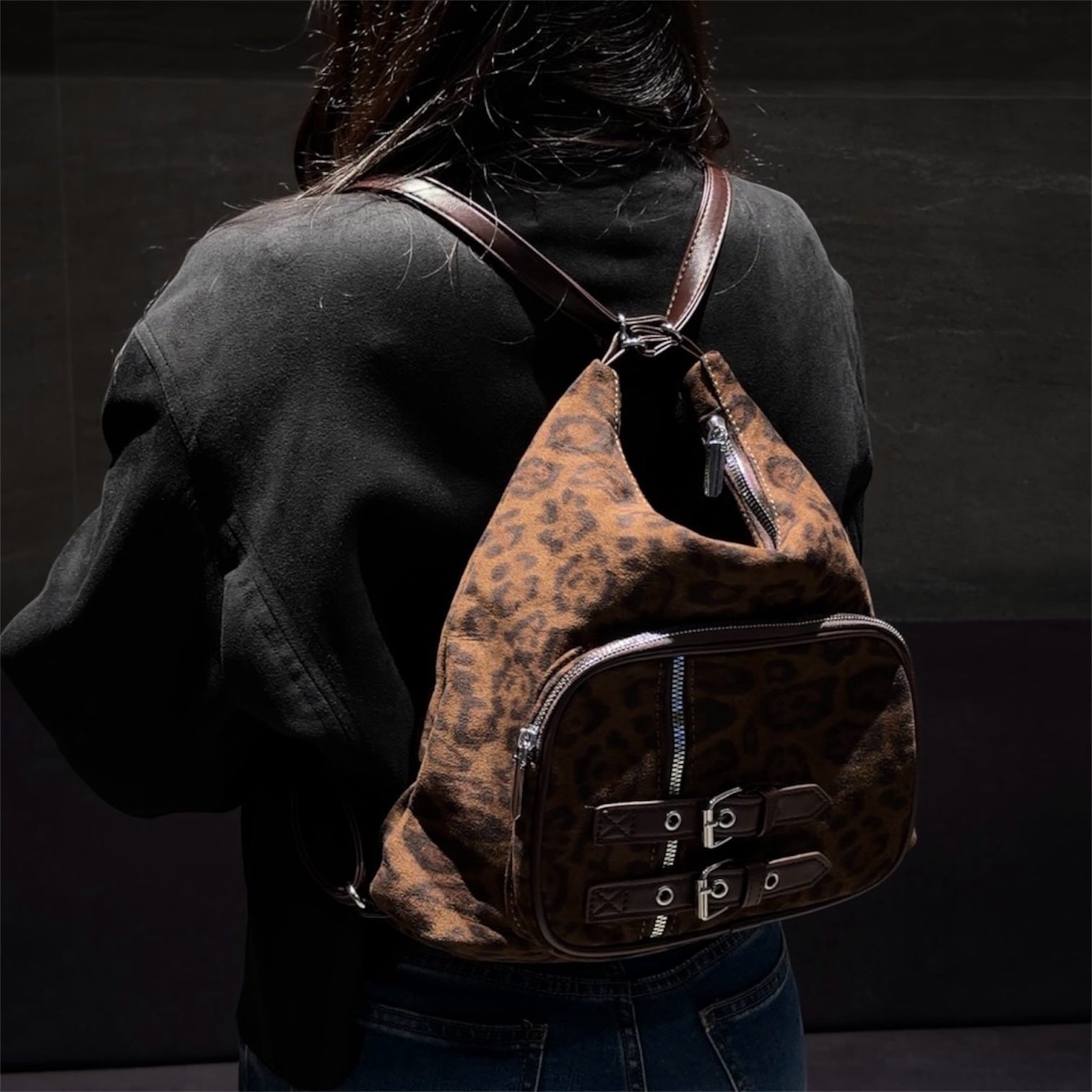 Cartera mochila convertible animal print con bolsillos y hebillas de diseño exclusivo.